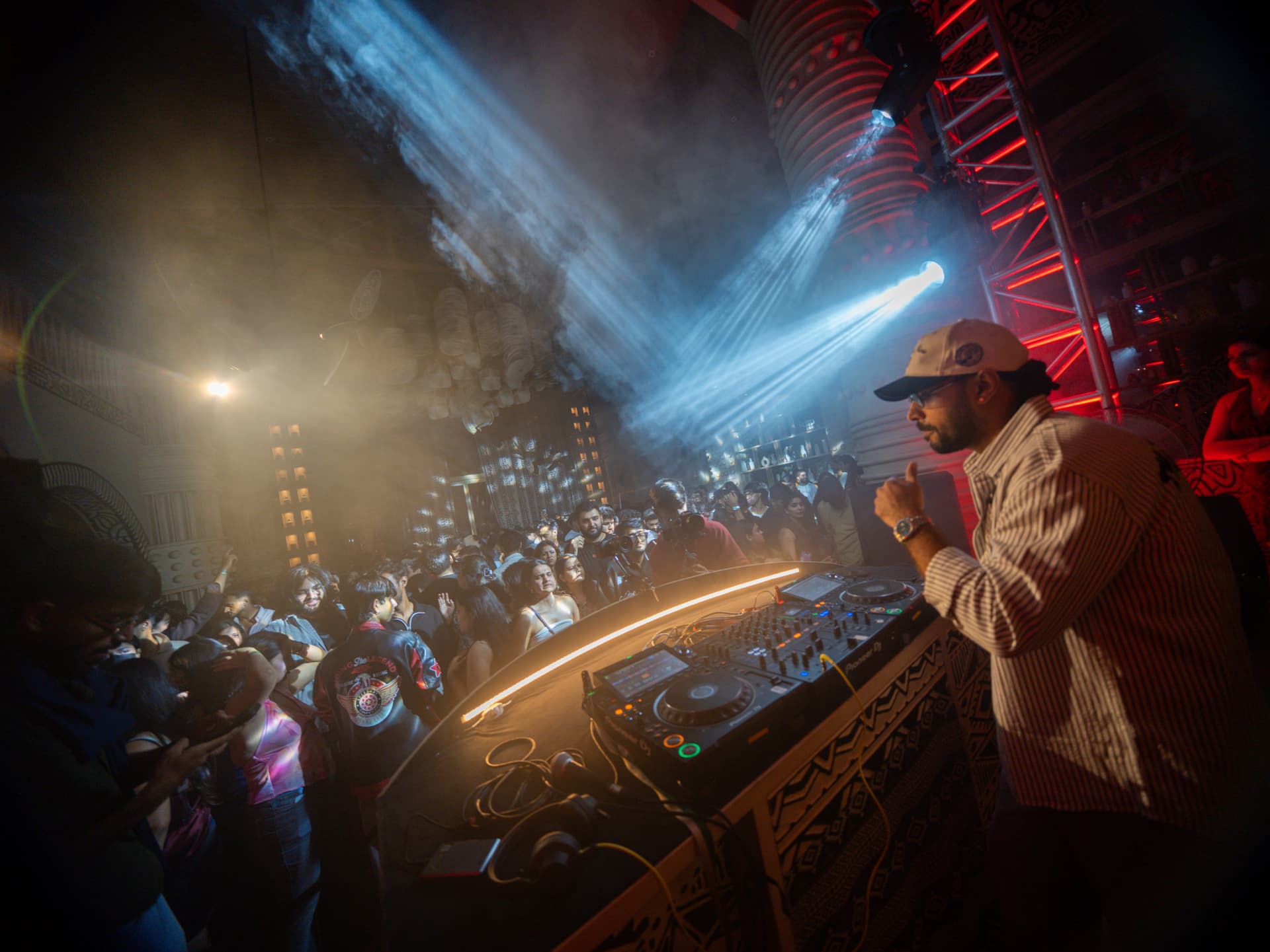 Performer at the decks beneath sweeping beams of stage light